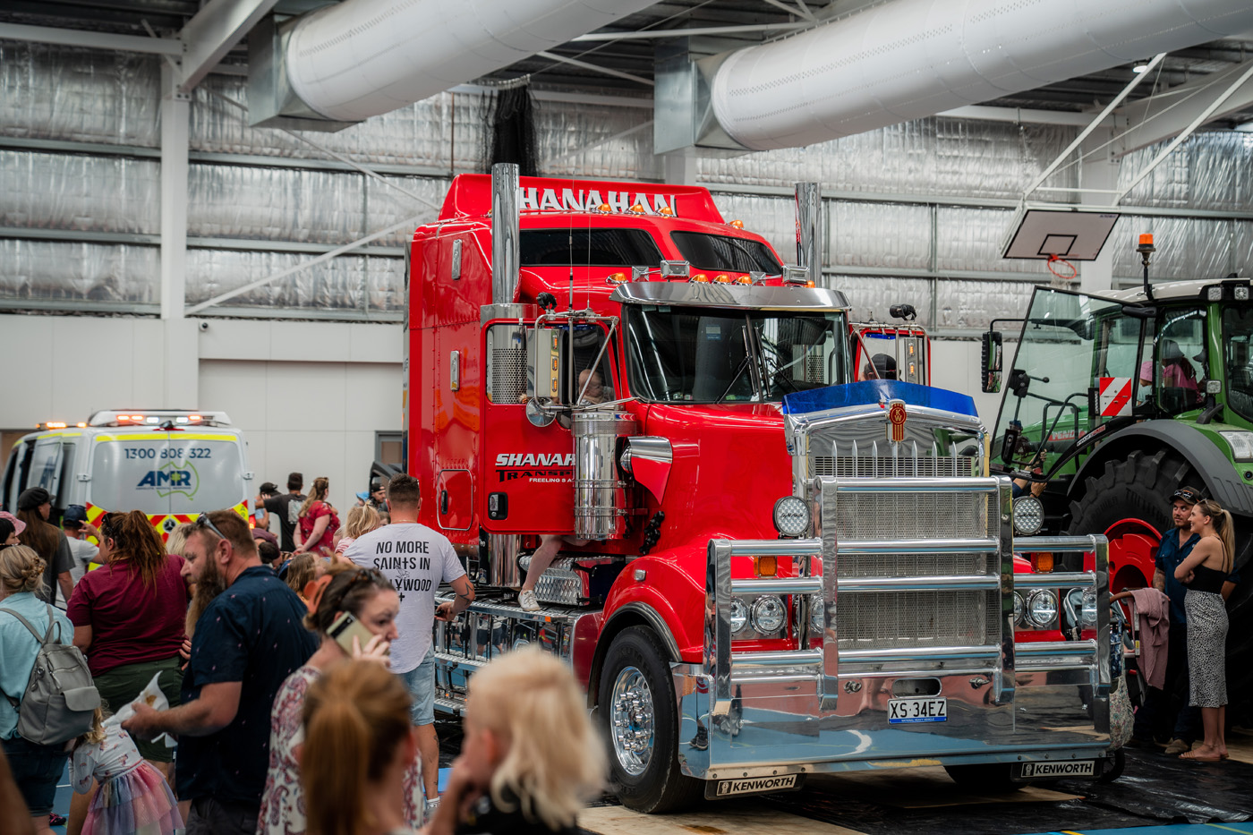 Large, red semi-trailer with people walking around it.