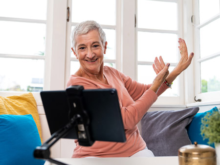 Lady copying instructors actions on electronic tablet screen